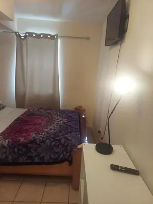 a bedroom with a bed and a table with a lamp at Deluxe Room A 12 minutes to Ewr in Newark