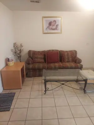 a living room with a brown couch and a table at Deluxe Room A 12 minutes to Ewr in Newark
