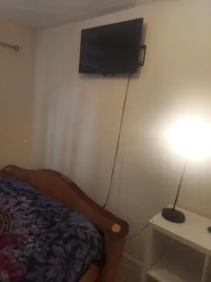 a room with a bed and a television on a wall at Deluxe Room A 12 minutes to Ewr in Newark