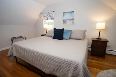a bedroom with a large white bed with blue pillows at 14mi to Mt. Snow! Arcade, Private Suite, King Bed! in Whitingham