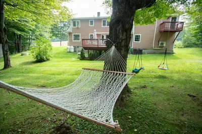 a hammock hanging from a tree in a yard at 14mi to Mt. Snow! Arcade, Private Suite, King Bed! in Whitingham