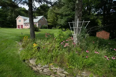 a garden with flowers in front of a house at 14mi to Mt. Snow! Arcade, Private Suite, King Bed! in Whitingham