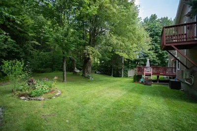 a yard with a tree and a deck at 14mi to Mt. Snow! Arcade, Private Suite, King Bed! in Whitingham
