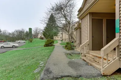 a sidewalk next to a house with a yard at East Stroudsburg Townhouse Less Than 1 Mi to Ski Area! in East Stroudsburg