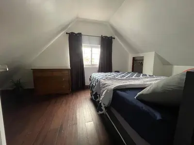 a bedroom with a bed and a dresser and a window at Private Loft 5 min away from LGA in East Elmhurst