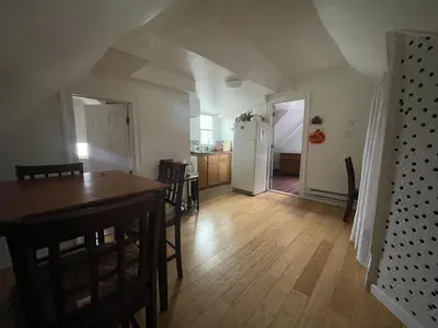 a kitchen and dining room with a table and a refrigerator at Private Loft 5 min away from LGA in East Elmhurst