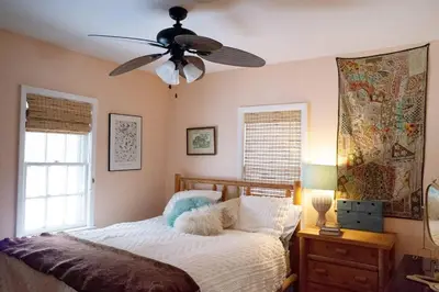 a bedroom with a bed with a ceiling fan at Enchanted Woodstock Cottage with hot tub in West Hurley