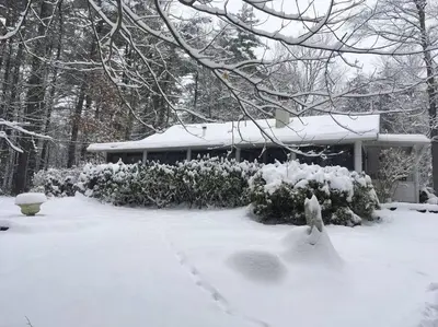 a yard covered in snow with a house in the background at Enchanted Woodstock Cottage with hot tub in West Hurley