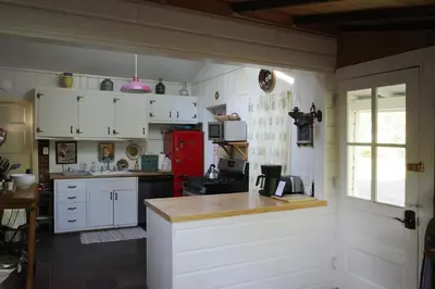 a kitchen with white cabinets and a red refrigerator at Enchanted Woodstock Cottage with hot tub in West Hurley