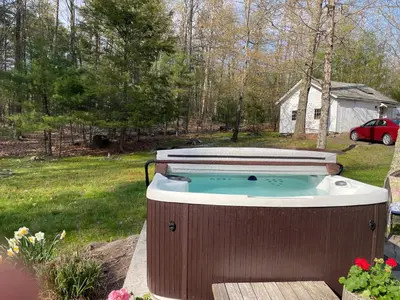 a hot tub in the backyard of a yard at Enchanted Woodstock Cottage with hot tub in West Hurley