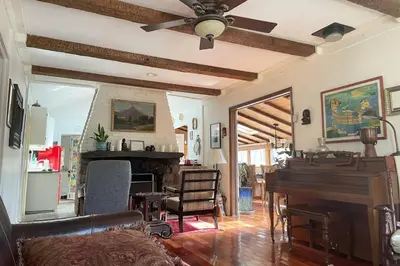 a living room with a ceiling fan and a piano at Enchanted Woodstock Cottage with hot tub in West Hurley