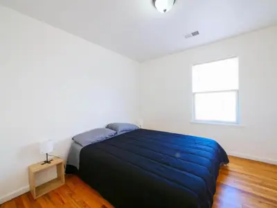 a bedroom with a blue bed and a window at Cozy 3 - Bed apartment, Minutes from NYC! in Jersey City