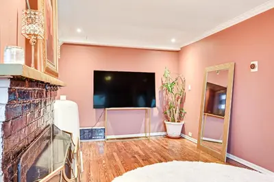 a living room with a fireplace and a flat screen tv at Welcoming Glen Cove Home about 1 Mi to Public Beach! in Glen Cove