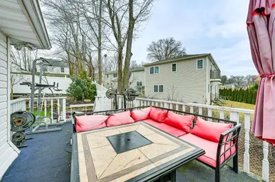 a patio with a couch and a table on a balcony at Welcoming Glen Cove Home about 1 Mi to Public Beach! in Glen Cove