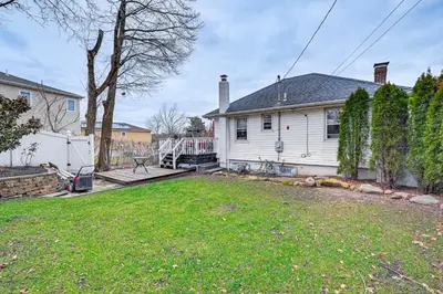 a white house with a yard in front of it at Welcoming Glen Cove Home about 1 Mi to Public Beach! in Glen Cove