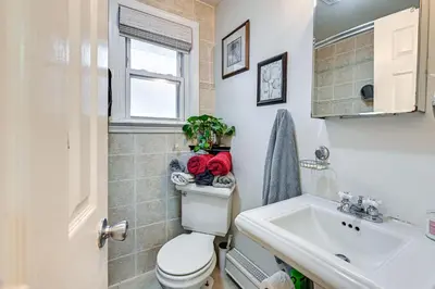 a bathroom with a toilet and a sink at Welcoming Glen Cove Home about 1 Mi to Public Beach! in Glen Cove