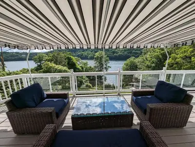 a screened in porch with chairs and a table at Candlewood Lake -Family Getaway, Lakefront 3775 sqft Home in Danbury