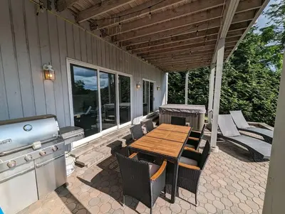 a patio with a wooden table and a stove at Candlewood Lake -Family Getaway, Lakefront 3775 sqft Home in Danbury