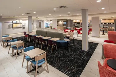 a restaurant with tables and chairs in a cafeteria at Home2 Suites By Hilton East Haven New Haven in East Haven