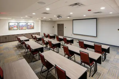 a classroom with tables and chairs and a projection screen at Home2 Suites By Hilton East Haven New Haven in East Haven