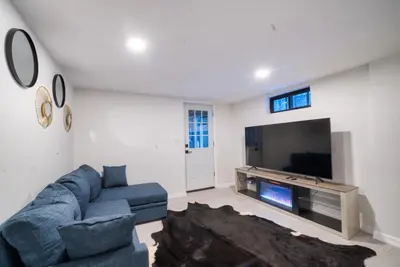 a living room with a blue couch and a tv at Brand New House with Huge Patio in Kerhonkson