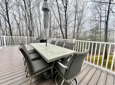a table and chairs on a deck with an umbrella at Brand New House with Huge Patio in Kerhonkson