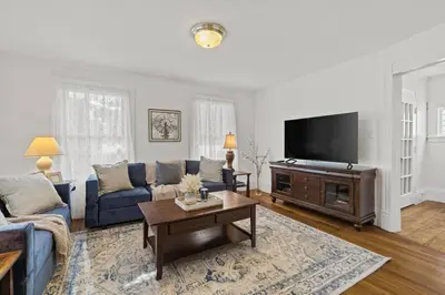 a living room with a blue couch and a tv at Prime West Hartford Center Location- Historic Gem in West Hartford
