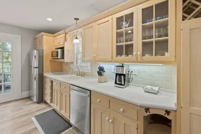 a kitchen with wooden cabinets and a refrigerator at Prime West Hartford Center Location- Historic Gem in West Hartford