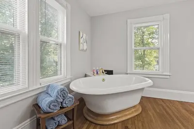 a white bathroom with a tub and two windows at Prime West Hartford Center Location- Historic Gem in West Hartford