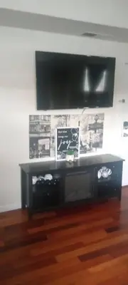 a black entertainment center with a flat screen tv on a wall at The place to relax in Schenectady