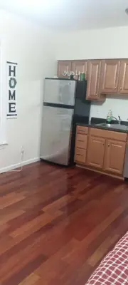 a kitchen with a stainless steel refrigerator and wooden floors at the rest spot in Schenectady