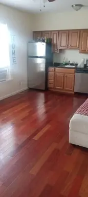 a kitchen with wooden floors and a stainless steel refrigerator at the rest spot in Schenectady