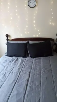 a bedroom with a bed with a clock on the wall at Suite 3 in Schenectady