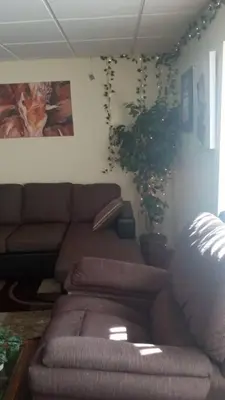 a living room with a couch and a plant at Suite 3 in Schenectady