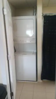 a white refrigerator with a washer and dryer in a room at Suite 3 in Schenectady