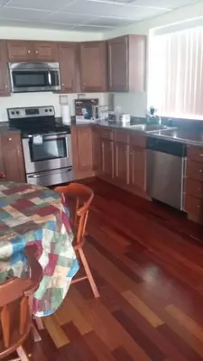 a kitchen with wooden cabinets and a kitchen with a table at Suite 3 in Schenectady