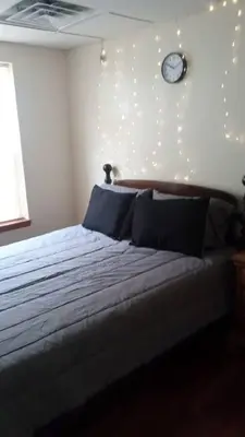 a bedroom with a bed with a clock on the wall at Suite 3 in Schenectady