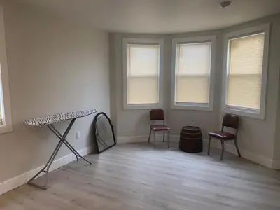 a room with two chairs and a table and windows at King Suite 8Mins to Newark Airport in Newark