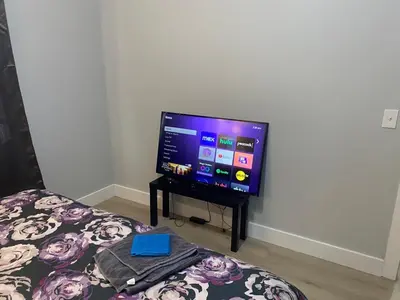 a flat screen tv sitting on top of a bed at King Suite 8Mins to Newark Airport in Newark