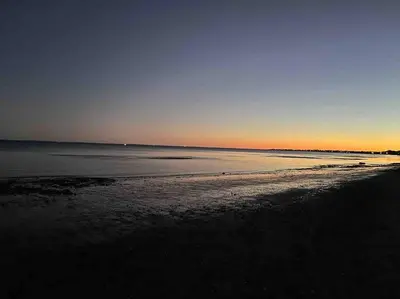 a view of the beach at sunset at Bobby's Beach Bungalow in Milford