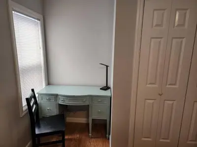 a desk with a lamp and a chair next to a door at Bobby's Beach Bungalow in Milford
