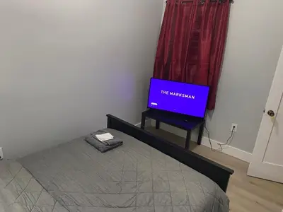 a bedroom with a bed and a tv in a room at Stylish Room 8Mins to Newark Airport in Newark