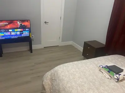 a bedroom with a bed and a flat screen tv at Stylish Room 8Mins to Newark Airport in Newark