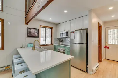 a kitchen with a sink and a refrigerator at Family-Friendly Big Bass Lake Vacation Rental! in Gouldsboro