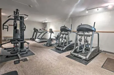 a gym with several tread machines in a room at Family-Friendly Big Bass Lake Vacation Rental! in Gouldsboro