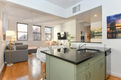 a kitchen with a sink and a living room at Luxury 3 Bedroom Retreat in Downtown Manhattan in New York