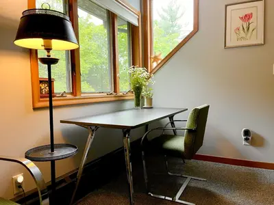a table and a lamp in a room with a window at Sunny Peace B&B in Harwinton