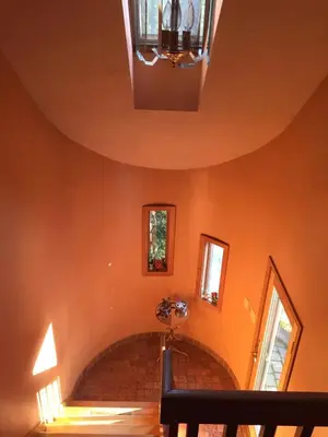 a hallway with orange walls and a chandelier at Sunny Peace B&B in Harwinton