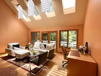a living room with a vaulted ceiling with skylights at Sunny Peace B&B in Harwinton
