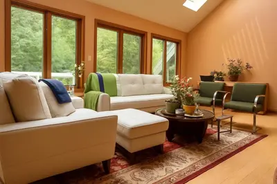 a living room with couches and chairs and windows at Sunny Peace B&B in Harwinton
